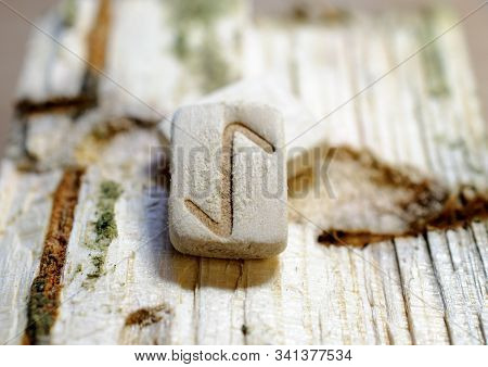 Wooden Rune Eihwaz Close-up On A Wooden Background. Soft Focus