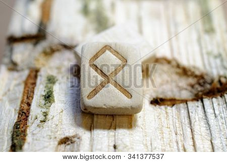 Wooden Rune Othila Close-up On A Wooden Background. Soft Focus