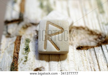 Wooden Rune Raido Close-up On A Wooden Background. Soft Focus