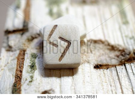 Wooden Rune Jera Close-up On A Wooden Background. Soft Focus