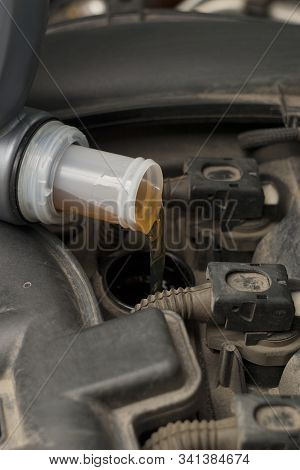 Refueling With Car Engine Oil. The Engine Compartment, Canister And Engine Oil Are Poured Into The O