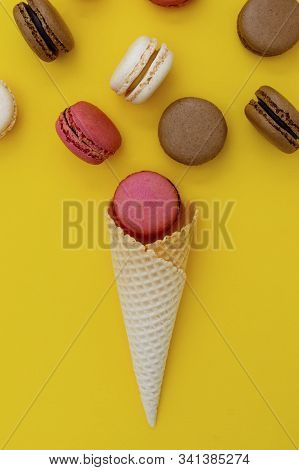 Macarons Cakes. Stil Life Photo Of Waffle Cone With Macaroons On Yellow Background. Flat Lay, Desser