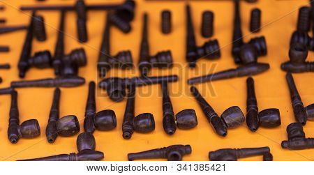 Different Pipes Smoking Tobacco On An Orange Background. Top View.