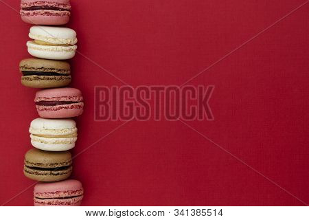 Macarons Cakes. Abstract Food Photo Background With Delicious Macaroons Over Red Background. Flat La