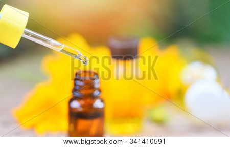 Aromatherapy Herbal Oil Bottles Aroma Dropper On Glass With Flower On Nature Green Background / Esse