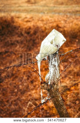 The White Paint Leaking From A Plastic Bottle Infuses Into A Spile On Autumn Background