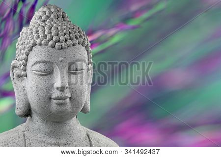 Buddha Statue Head Isolated On Blurred Green And Purple Background With Copy Space