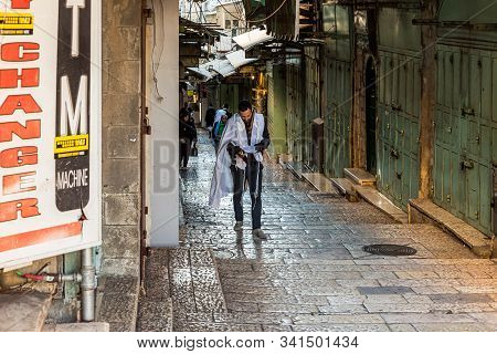 Jerusalem, Israel, December 28, 2018 : Religious Jew Reads A Holy Book And Walks Down The David Stre