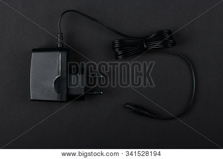 Black Power Ac To Dc Adaptor. Power Adapter Of Router Isolated On Black Background. High Resolution 