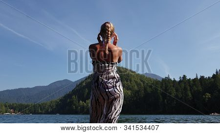 Woman Walk On Water On Pier In Sunglasses And A Boho Silk Shawl. Girl Rest On Flood Wood Underwater 