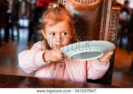Cute Preschooler Girl Asks For Food With Empty Plate In Hands