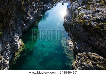 Limpid Mountain Stream Flows Cold Among Millennial Rocks Of The Vicenza Alps Carved Out By Time In C