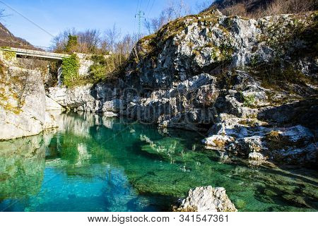 Limpid Mountain Stream Flows Cold Among Millennial Rocks Of The Vicenza Alps Carved Out By Time In C