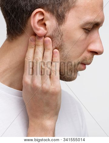 Close Up Portrait Of Sick Man Touches The Lymph Glands With His Fingers Near The Ear, Suffering From