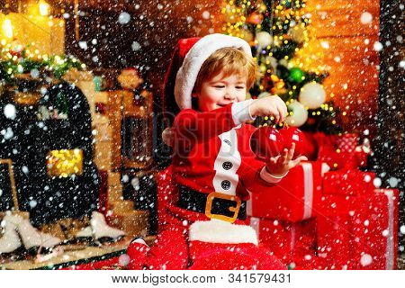 Gifts For Winter Holidays At Fire Place. Little Boy With Christmas Presents. Joy And Happiness. Chil