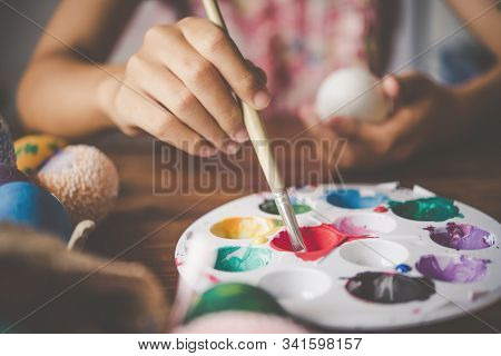Young Girl Painting Easter Eggs For Eastertime At Home