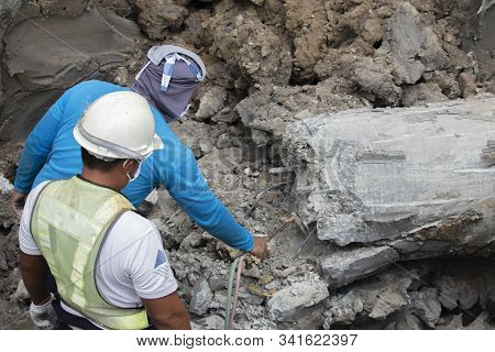 Two Workers Are Helping To Cut The Steel Wire By Gas In The Concrete Pile.