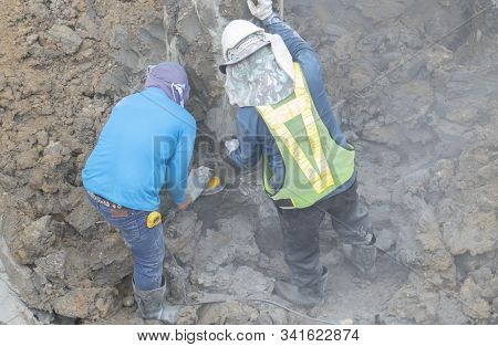 Two Workers Are Helping To Cut The Steel Wire By Gas In The Concrete Pile.