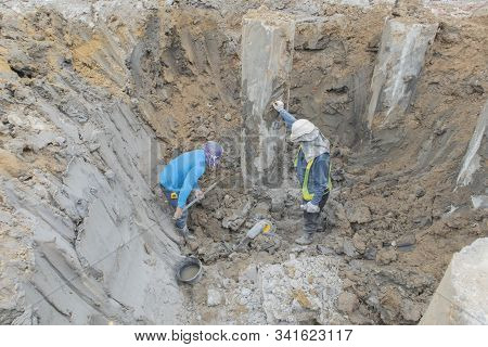 Two Workers Are Helping To Cut The Steel Wire By Gas In The Concrete Pile.