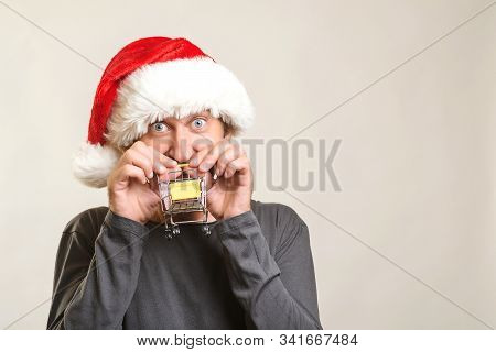 Excited Man Going To Christmas Shopping. Christmas Sales And Discounts. Handsome Guy In Santa Hat. H