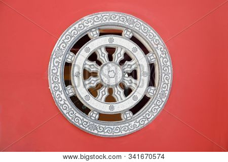 Stone rosette relief - window made of decorated stone relief, ornaments and relief on the red wall from Chinese buddhism temple, Fujian,China.