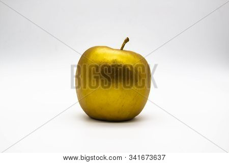 A Golden Apple On A White Background