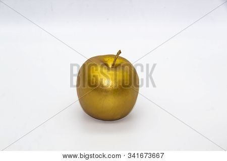 A Golden Apple On A White Background