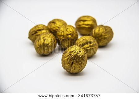 A Golden Walnuts On A White Background