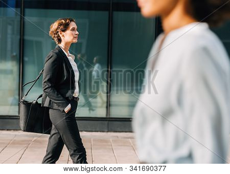 Businesswoman Commuting To The Office Carrying Her Bag. Woman In Formalwear Walking Outdoors.