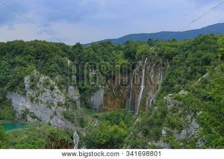 Small Waterfalls In The Wild Green Trees And River