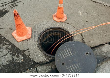 Repair Work On Troubleshooting Or Communal Service Work. Open Iron Hatch With Cable Going Inside.