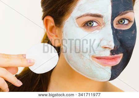 Woman With Clay Carbo Black Mask On One Half Face And White Mud On Second Half. Girl Removing Cosmet