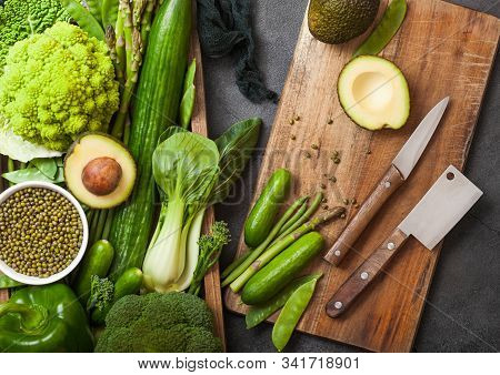 Assorted Green Toned Raw Organic Vegetables In Wooden Box On Dark Stone Background. Avocado, Cabbage