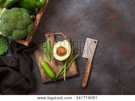 Assorted Green Toned Raw Organic Vegetables In Wooden Box On Dark Stone Background. Avocado, Cabbage