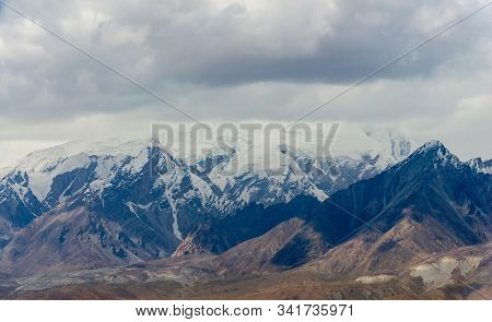 Panoramic View Of Snow Capped Mountain Ranges And Cloudscape Of Kunlun Mountians In Pamirs Plateau I