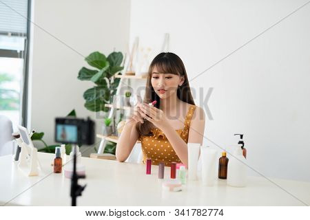 Bright Colour. Nice Happy Woman Showing A Shiny Lipstick While Recording A Video For Her Blog