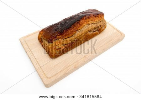 A Homemade Plumcake Standing On A Wooden Board With A White Background