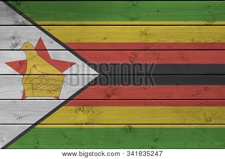 Zimbabwe Flag Depicted In Bright Paint Colors On Old Wooden Wall. Textured Banner On Rough Backgroun