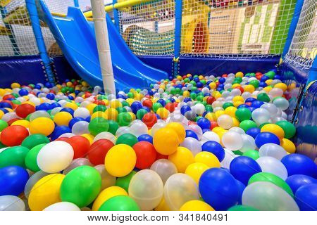 Kids Playground Indoor. Panoramic View Inside The Dry Pool With Colorful Balls And Slide. Nice Plast