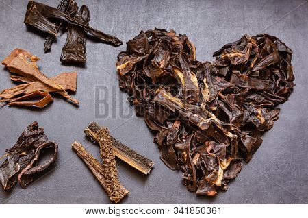 The Image Of The Heart Is Laid Out From Treats For Dogs. Natural Dried Treats For Dogs On A Dark Bac
