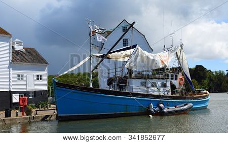 Woodbridge, Suffolk, England - May  04, 2019: Old Sailing Boat Moored Outside Famous Tide Mill.