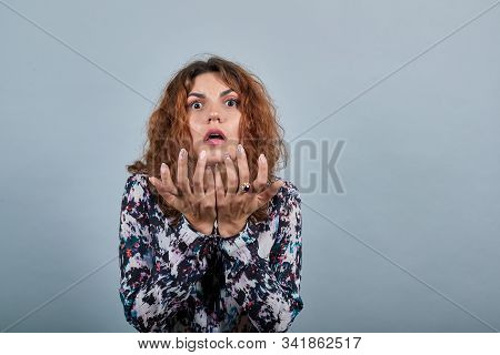 Schocked Pretty Brunette Caucasian Young Woman Looking At Camera With Opened Mouth, Spreads Hands, C