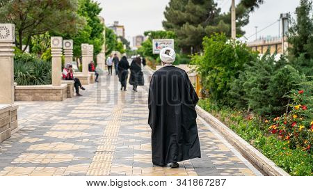 Qom, Iran - May 2019: Iranian Man Walking A Street In Qom, Which Is Considered By Shia Muslims To Be