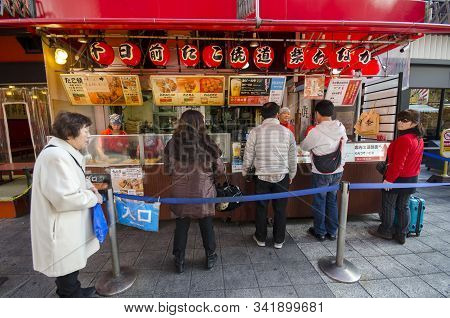Osaka, Japan- 03 Dec, 2019: Customers Queueing In Front Of Takoyaki Octopus Balls Stall At Dotonburi
