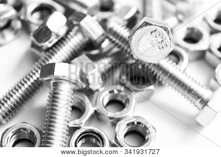 Metal Bolts And Nuts  In A Row Background. Chromed Screw Bolts And Nuts Isolated. Steel Bolts And Nu