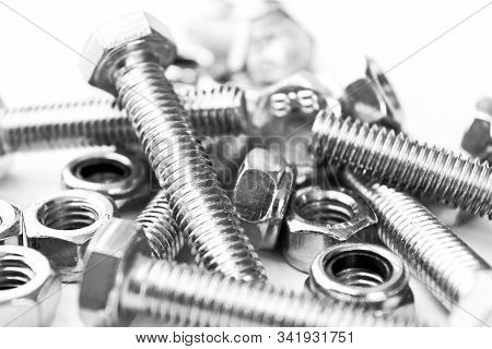 Metal Bolts And Nuts  In A Row Background. Chromed Screw Bolts And Nuts Isolated. Steel Bolts And Nu