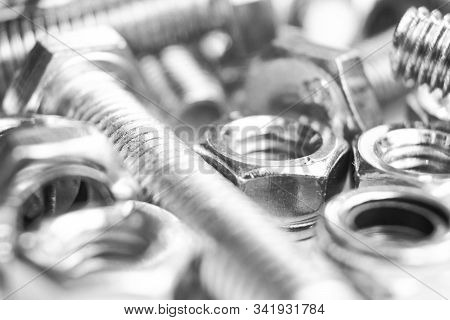 Metal Bolts And Nuts  In A Row Background. Chromed Screw Bolts And Nuts Isolated. Steel Bolts And Nu