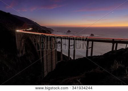 Car Light Trails Illuminating Bixby Bridge On A Winter Dusk. Big Sur, Monterey County, California, U