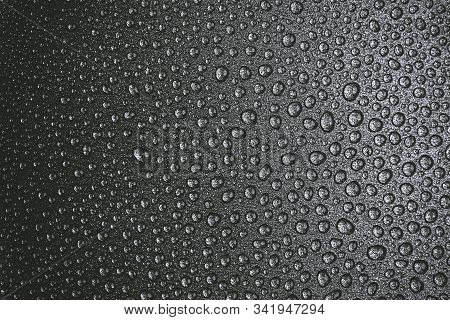 Abstract Background: Many Drops Of Water On A Dark Surface - Non-stick Coating In A Pan. Black And W