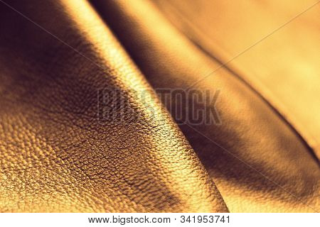 Genuine Leather. Brown Background Gold Color. The Texture Of The Skin Close-up. Bends Of The Skin.